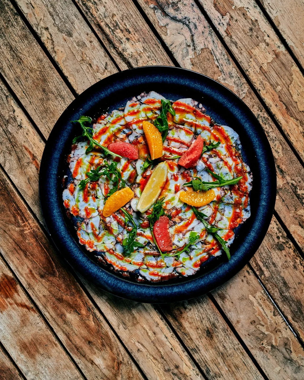 Carpaccio de poulpe aux agrumes et roquette